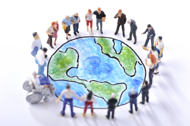 地球の絵を囲むさまざまな人たち