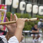 秋田の昼竿灯祭りで篠笛を吹く女性
