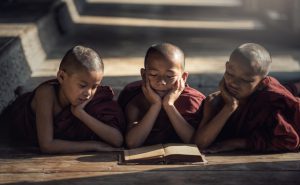 一緒に本を読む３人の子供の僧侶