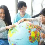 地球儀を囲む笑顔の子供たち