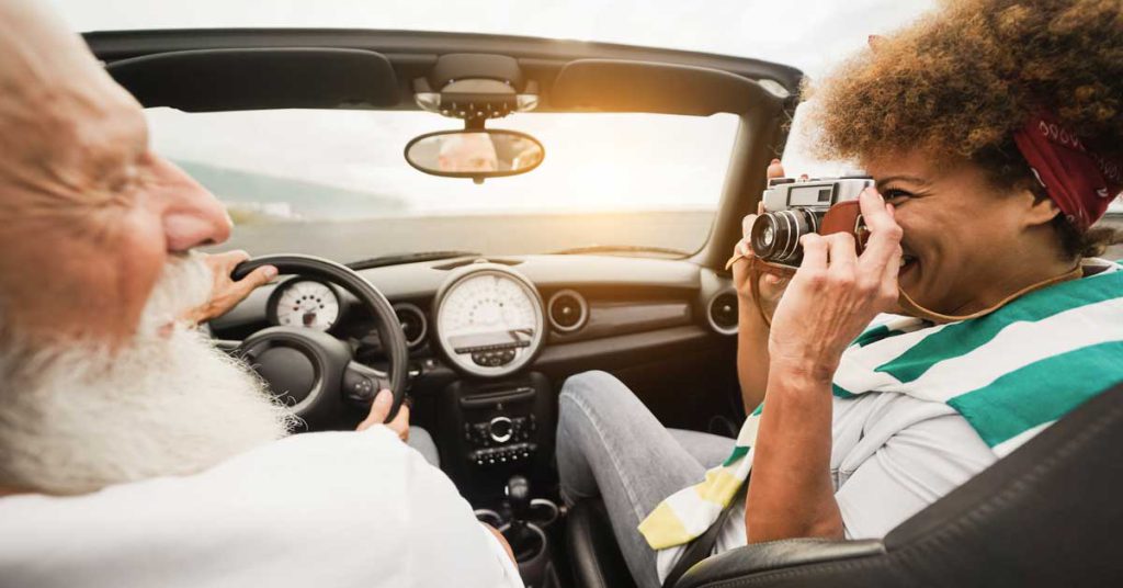 オープンカーでドライブを楽しむ老夫婦