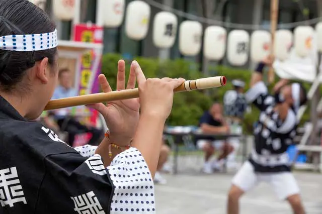 祭りで笛を吹く男性