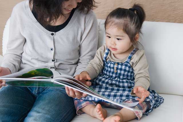 母親と読書する小さい子供