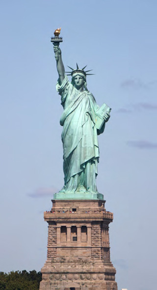 この巨大な像の高さは、15 階建てのビルに相当します。今までに、何百万という数の移民が、エリス島に第一歩を踏み入れるときに自由の女神に目を凝こ らしました。
