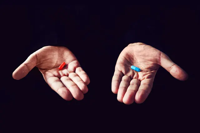 右手に置かれた赤い薬と、左手に置かれた青い薬